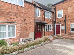 a brick building with a red door and a bench at Hambleton House Castle Donington in Castle Donington