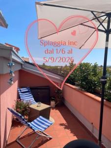 Un cartel en un balcón con dos sillas y un corazón. en Casa Gioia, en Marcelli