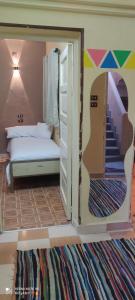 sypialnia z łóżkiem oraz drzwi ze schodami w obiekcie Nasser Nubian Guest House w mieście Jazīrat Aswān