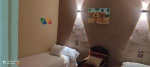 sypialnia z 2 łóżkami i lampkami na ścianie w obiekcie Nasser Nubian Guest House w mieście Jazīrat Aswān +17 zdjęć