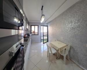 a kitchen with a table and chairs in a room at Ryad el houda in Agadir