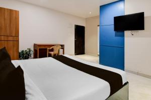 a bedroom with a bed with a blue cabinet and a desk at Hotel O Avigna Premium in Bhubaneshwar +21 photos