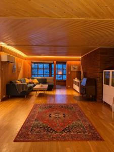 a living room with a couch and a rug at Charming and spacious wooden house right in the city centre in Tromsø