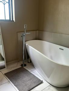 Una bañera blanca en un baño con ventana. en Riverside Gardens 2 bedroom Home, en Nelspruit 8 fotos más