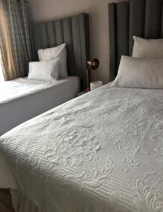 Un dormitorio con dos camas con sábanas blancas. en Riverside Gardens 2 bedroom Home, en Nelspruit