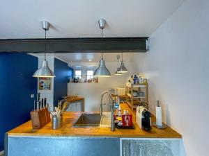 een keuken met een spoelbak en drie hanglampen bij Ti Yoco in Ploubazlanec +38 foto's