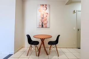 einen Tisch und zwei Stühle vor einer Wand in der Unterkunft Lindo apê pertinho de tudo in Ourinhos