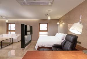 um quarto com uma cama, um sofá e uma mesa em Capace Hotel Gangnam em Seul