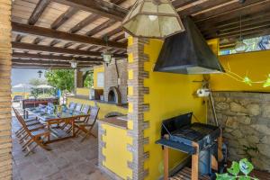 an outdoor kitchen with a stove and a table at Villa La Casetta in Sonnino
