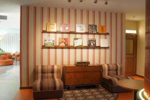 a living room with two chairs and a table and shelves at The Très Hotel in Kuala Lumpur