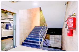 schody w budynku z czerwoną gaśnicą w obiekcie Kalinga Guest House Bhubaneswar w mieście Cuttack