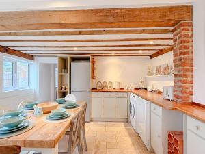 a kitchen with a wooden table with blue dishes on it at Hainford Cottage in Hainford