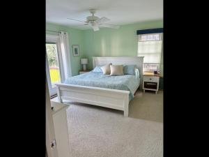 a bedroom with a bed and a ceiling fan at Island Time home in Holden Beach