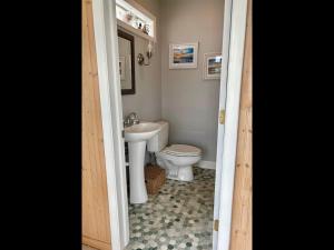 a bathroom with a toilet and a sink at Island Time home in Holden Beach