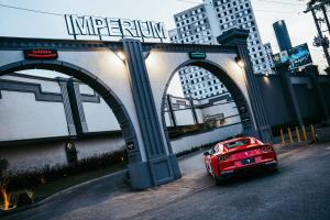 a red car parked under a bridge in a city at Motel Imperium in Osasco
