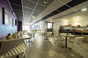 a dining room with tables and chairs in a restaurant at Nemea Appart Hotel Quai Victor Tours Centre in Tours
