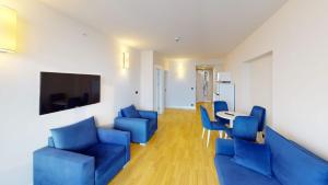 ein Wohnzimmer mit blauen Stühlen und einem Tisch in der Unterkunft Orbi City VIP Apartments In Batumi Center in Batumi