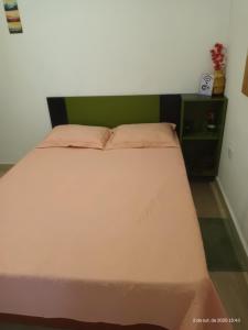 un letto grande in una camera da letto con testiera verde di Cantinho de casa a Votuporanga