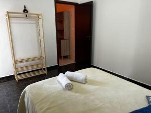 a bedroom with a bed with two towels on it at Pousada Jandi in São Miguel Arcanjo