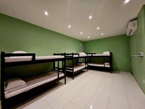ein Zimmer mit drei Etagenbetten mit einer grünen Wand in der Unterkunft Praculá Hotel in Belém