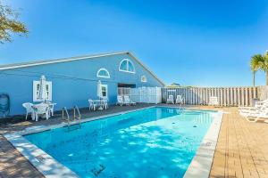 a swimming pool in front of a blue house at Neptunes Palace A1 in Saint George Island +12 photos