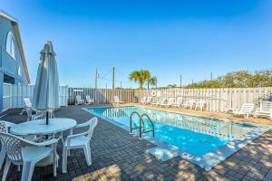 a patio with a table and chairs and a pool at Neptunes Palace A1 in Saint George Island