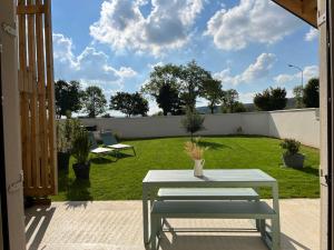 a patio with a table and a field of grass at HÔME Les hauts du Val in Vantoux