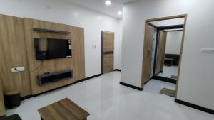 a living room with a tv and a wooden wall at Embassy Grand in Jāmb