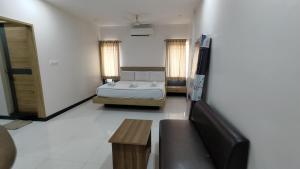 a bedroom with a bed and a couch in a room at Embassy Grand in Jāmb +9 photos