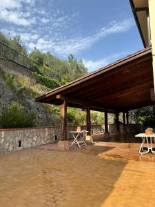 a pavilion with a picnic table and a stone wall at Benesié - Villa with castle view in Monte San Giovanni Campano