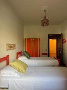 a bedroom with three beds with a chandelier at Benesié - Villa with castle view in Monte San Giovanni Campano