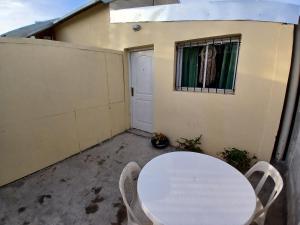 a white table and chairs on a patio with a window at Alojamientos viedma in Viedma