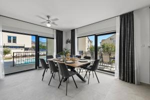 a dining room with a table and chairs and large windows at Villa Lav Lux Elegant Residence with Private Heated Pool in Mlini +76 photos