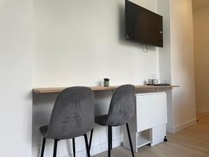 due sedie su una scrivania con una televisione su una parete di Studio dans la résidence Hermitage a Le Touquet-Paris-Plage