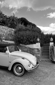 a white car parked in front of a stone wall at Holidays Perla d'Amalfi - Live the Coast & Private Parking in Amalfi