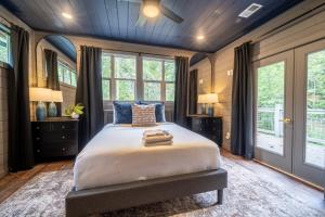 a bedroom with a large bed and windows at Multi Level Getaway Pool Hot Tub and Fireplace in Pittman Center +33 photos