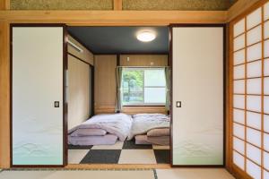 a bedroom with a bed in a room with sliding glass doors at テントサウナがある家 余市町 in Kurokawamachi