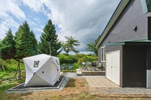 a dog house sitting outside of a house at テントサウナがある家 余市町 in Kurokawamachi