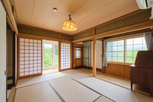 an empty room with windows and a chandelier at テントサウナがある家 余市町 in Kurokawamachi