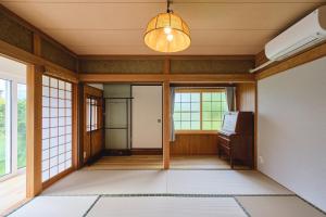 an empty room with a door and a chandelier at テントサウナがある家 余市町 in Kurokawamachi