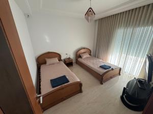 a bedroom with two beds and a tv in it at Luna Loft in La Soukra