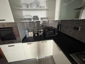 a kitchen with white cabinets and a black counter top at Luna Loft in La Soukra