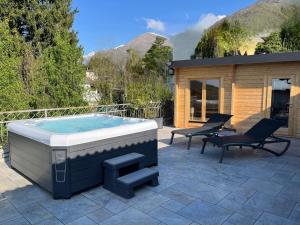 a hot tub sitting on a patio with two chairs at La Stella delle Alpi in Vico Canavese