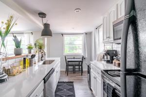 cocina con encimeras blancas, fregadero y mesa en Short North Convention Private Parking Pet, en Columbus