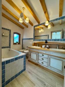 Un baño con bañera y dos lavabos y un inodoro. en Vila Luna Brașov, en Brasov