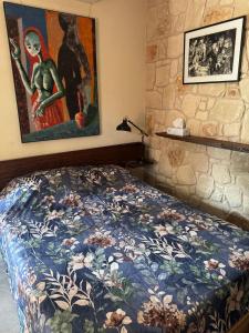 a bedroom with a bed and a painting on the wall at Traditional Stone House - Where Tradition Meets Comfort in Mesa Chorio