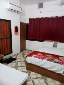 Un dormitorio con una cama y una cortina roja. en The banaras residency, en Varanasi