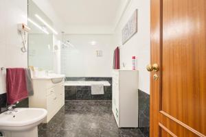 a white bathroom with a sink and a toilet at CasaFernandes 15 - Lisbon near Metro line in Odivelas +66 photos
