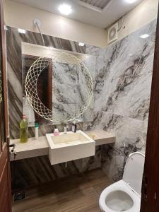 een badkamer met een wastafel en een spiegel bij Luxury 2BR Near Icon 36 2 AC, 2 TV & City View in Karachi +27 foto's