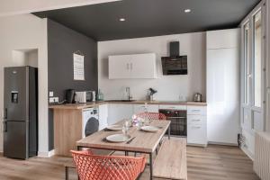 eine Küche mit Tisch und Stühlen und einem Kühlschrank in der Unterkunft T3 centre ville 70 m2 avec terrasse in La Baule + 54 Fotos